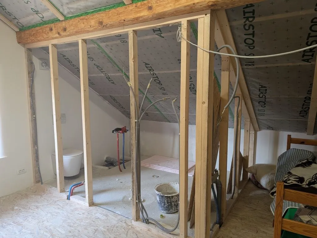 The framed bathroom walls. The conduit running up the studs will supply the bathroom lights, ventilation fan, and outlets.