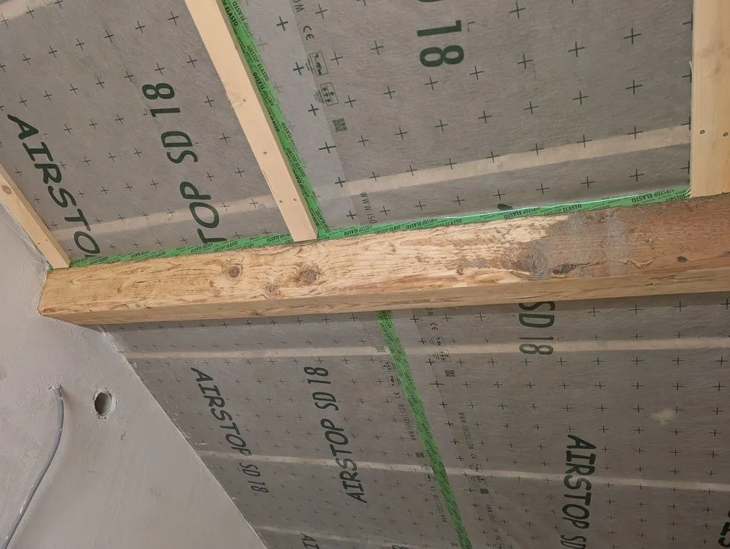 Sanding the beams in progress—the sanded surface is on the left, and the original rough-sawn surface on the right.