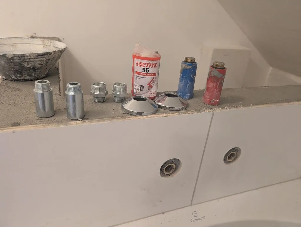 The various materials for installing the bathtub faucet (fittings, escutcheons, sealing thread, the old temporary plugs).