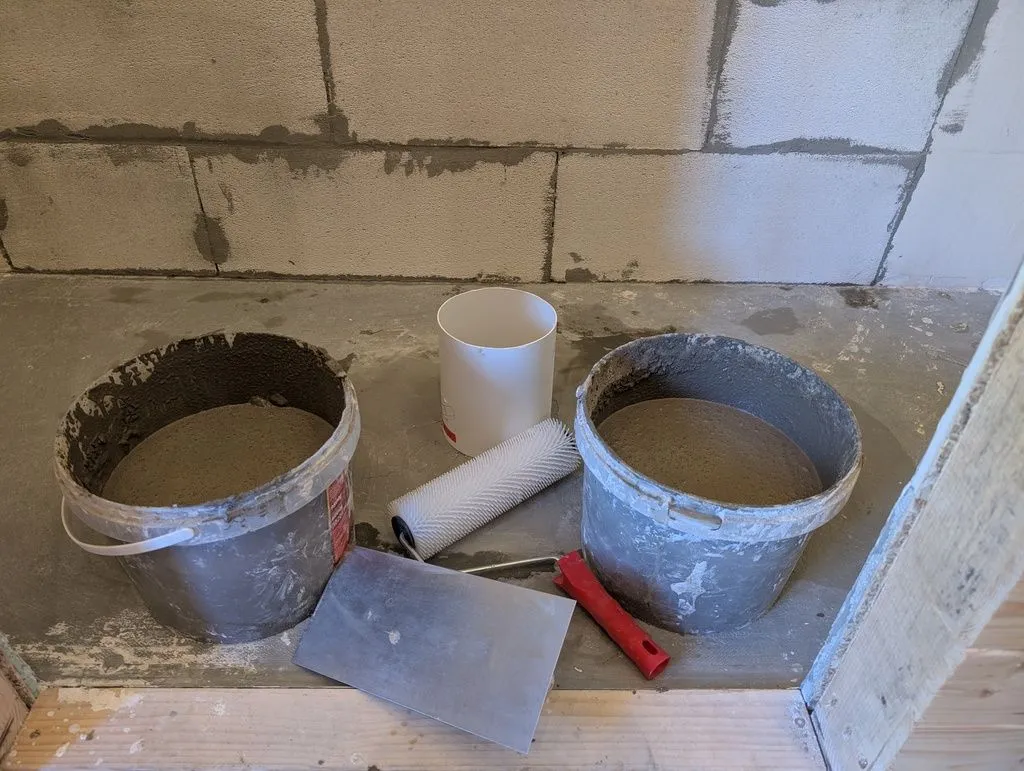 The self-leveling compound is cementitious/mineral-based and bonds nicely to the cementitious screed floor. You mix the material you'll need in buckets, then pour it all at once.