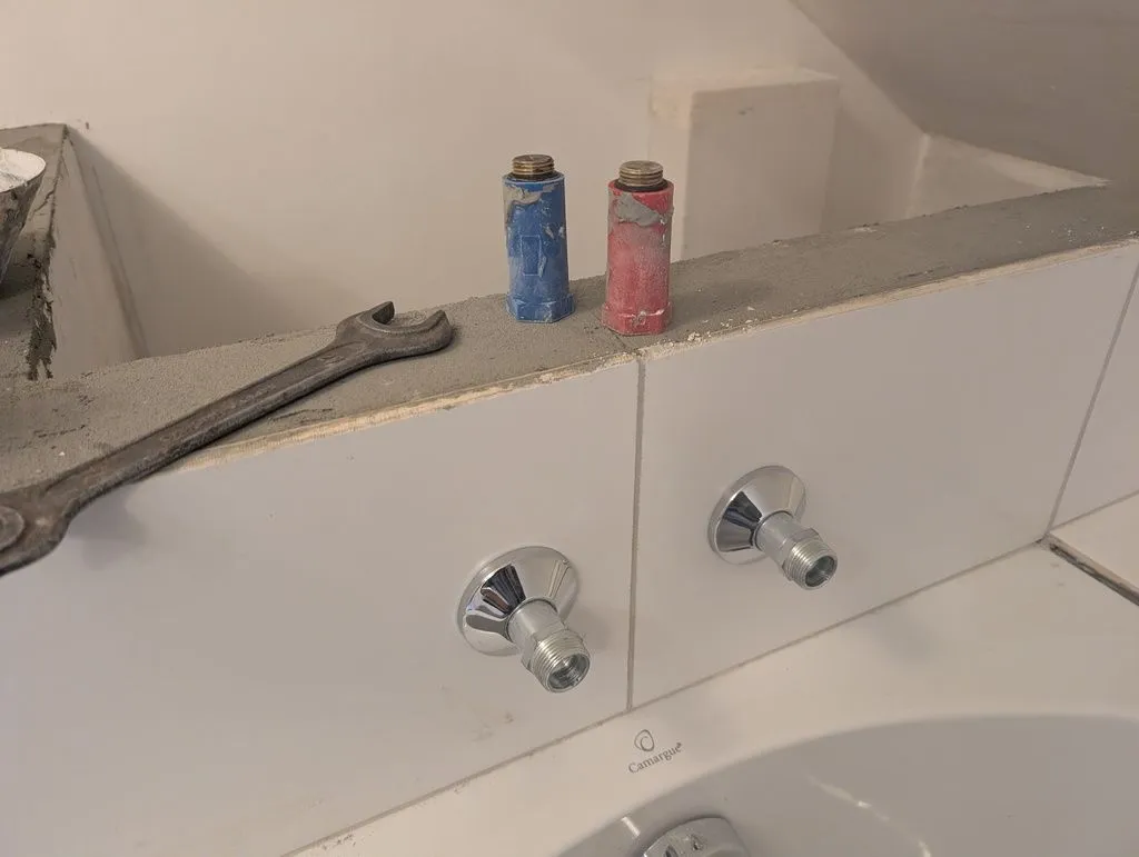 The installed fittings. The fittings intentionally project out of the wall so the water from the faucet will comfortably reach over the lip of the bathtub..