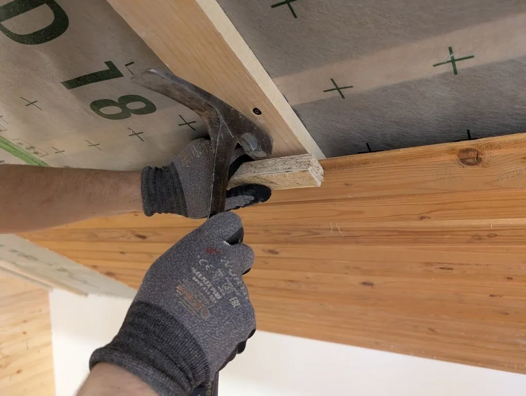 We used a jig made from a piece of tongue and groove OSB to fit the boards tightly. (Hitting the boards directly with a hammer would cause them to split, but the OSB jig fits over the boards and distributes force sufficiently safely.)