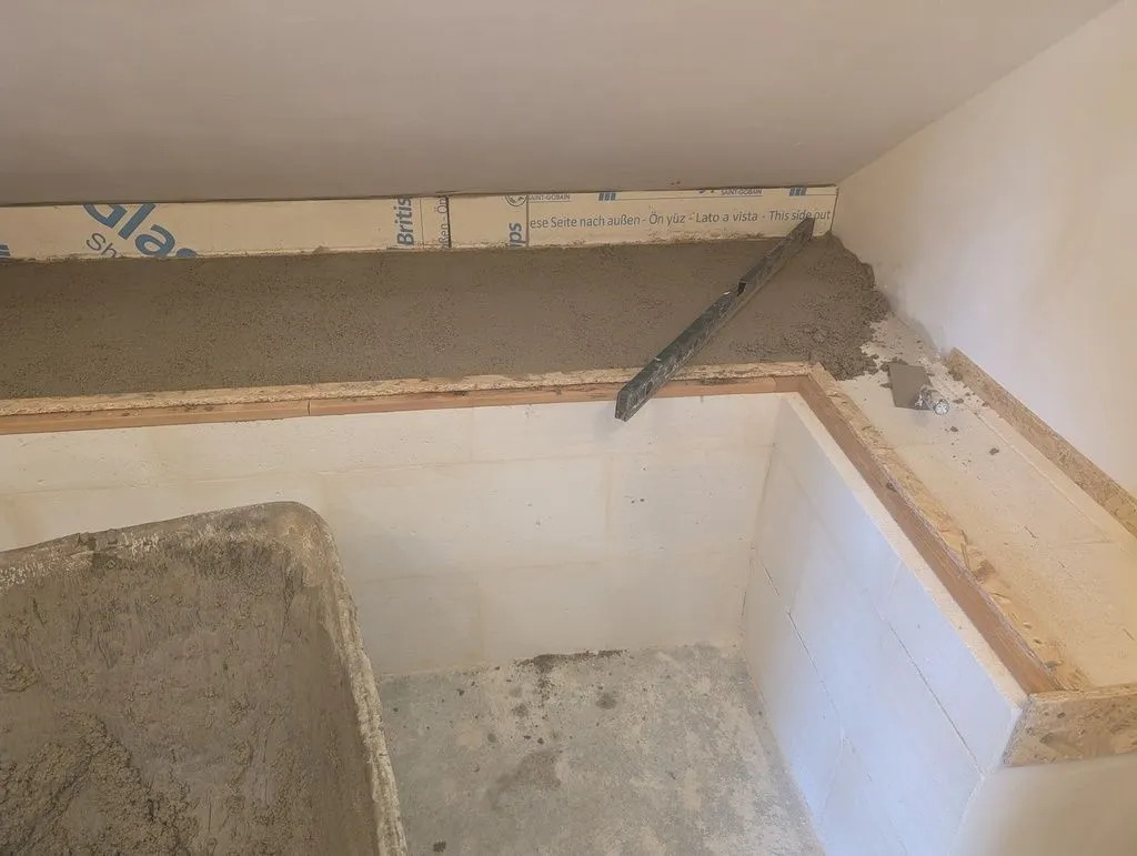 Striking off the screed using a level as a straightedge.