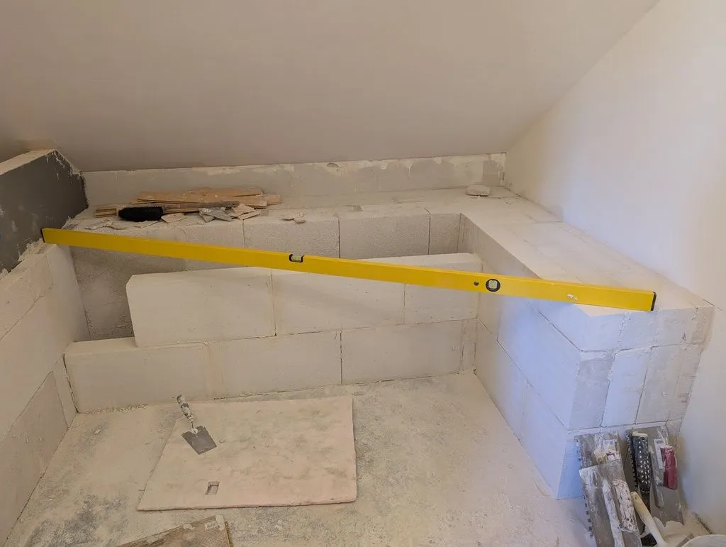 Checking the walls for level. The wall in the foreground will support the bathtub; the area in the back will be a flat space on which to place towels, soap, etc.