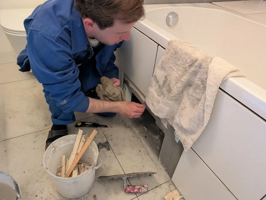 Martin did a wonderful job of cleaning up the thinset I spread everywhere with my inexperienced hands. The hole in the wall is for an access hatch for servicing the bathtub plumbing—more on this below.
