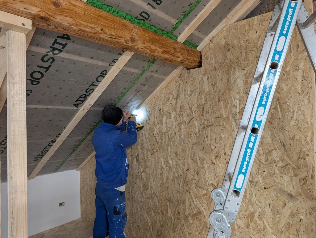Martin fastening the OSB to the studs—we worked together on the sheathing—I did the cutting and he did the fastening.