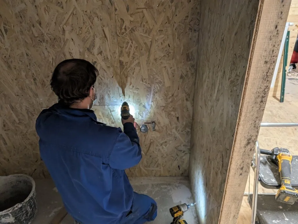 Martin helped throughout sheathing of the bathroom walls. Here he is attaching the final board.