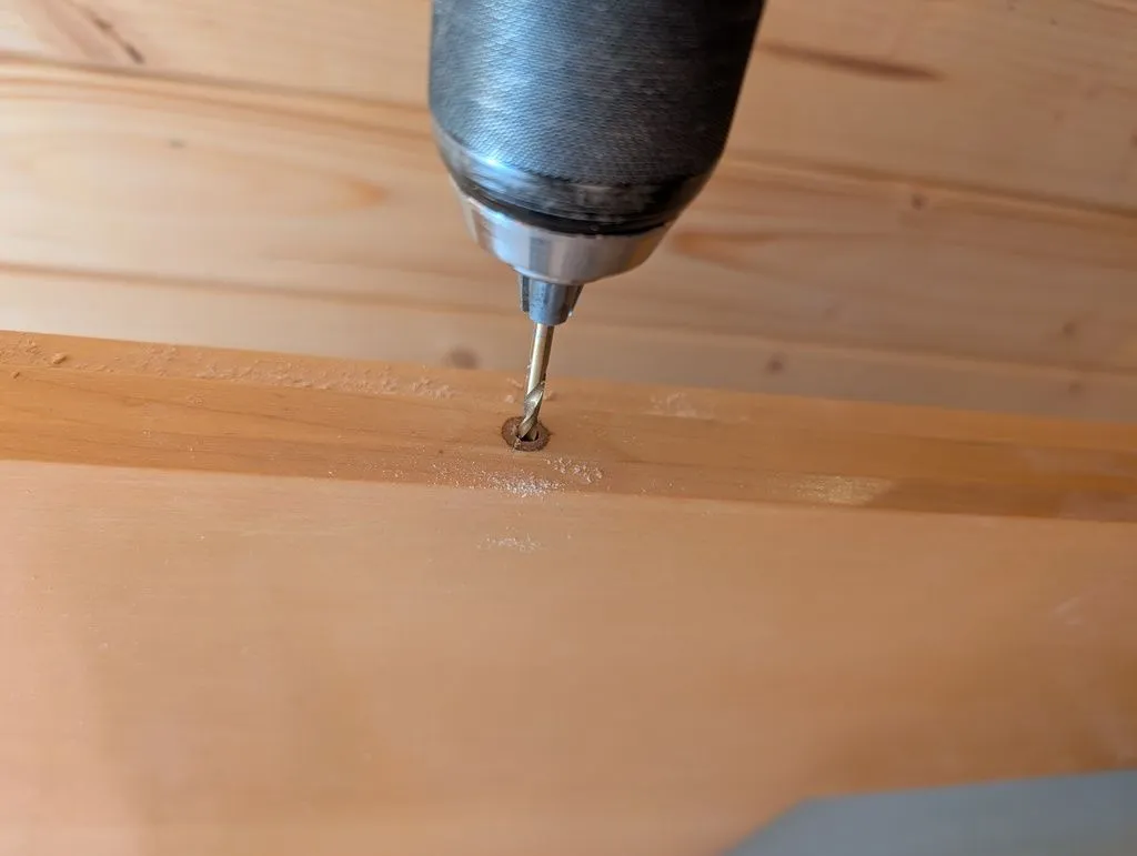 Drilling a starter guide hole with a thin-diameter drill bit.