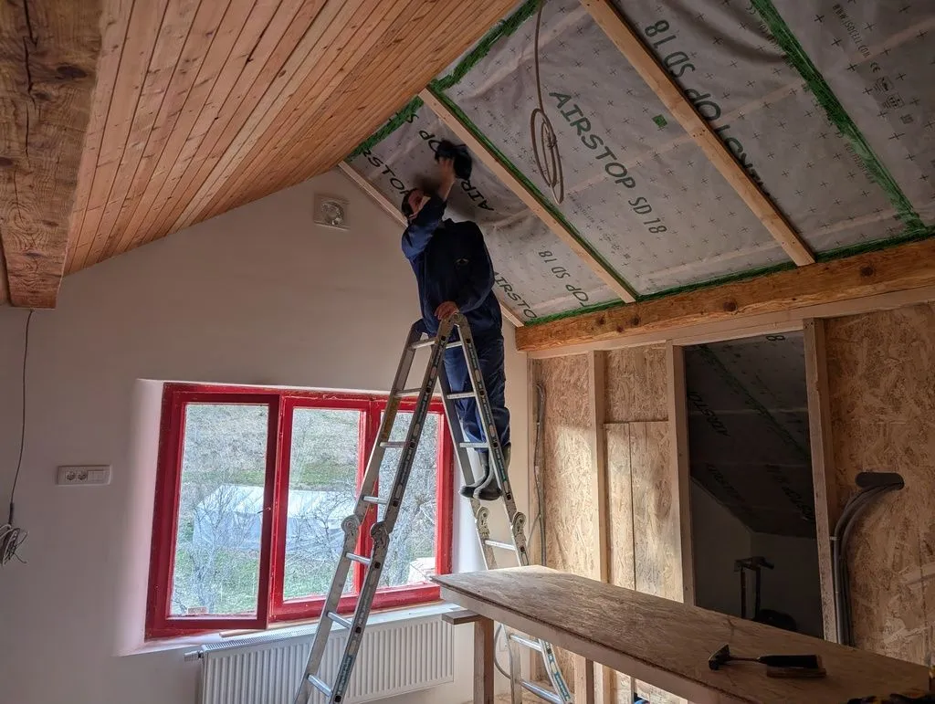 Martin wiping down the ceiling before installing the tongue and groove boards.
