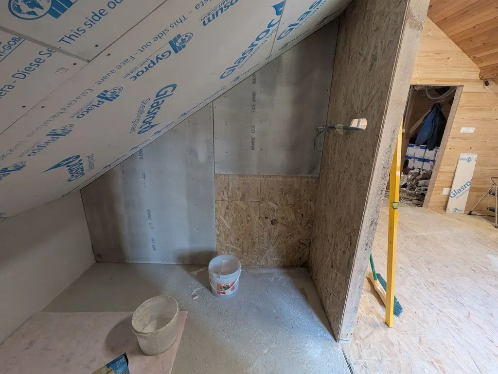 Installing the first pieces of cement board (we used cement board in the water-exposed areas near the bathtub and sink).