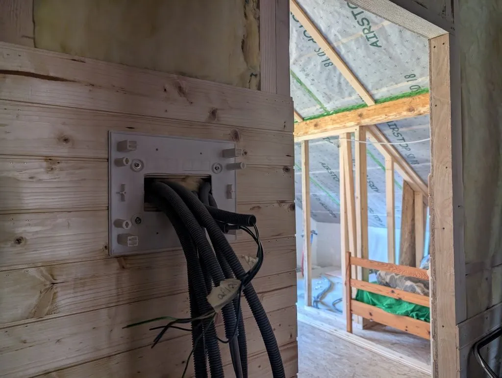 The panel's subframe attached to the wall, with conduit routed into the panel.