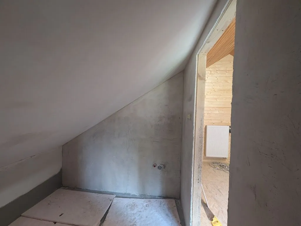The completed interior surfaces after taping and finishing. We finished the drywall with standard gypsum-based drywall compound and finished the cement board with a lime-cement render. The ceiling and some of the walls will later be painted, and some tiled.
