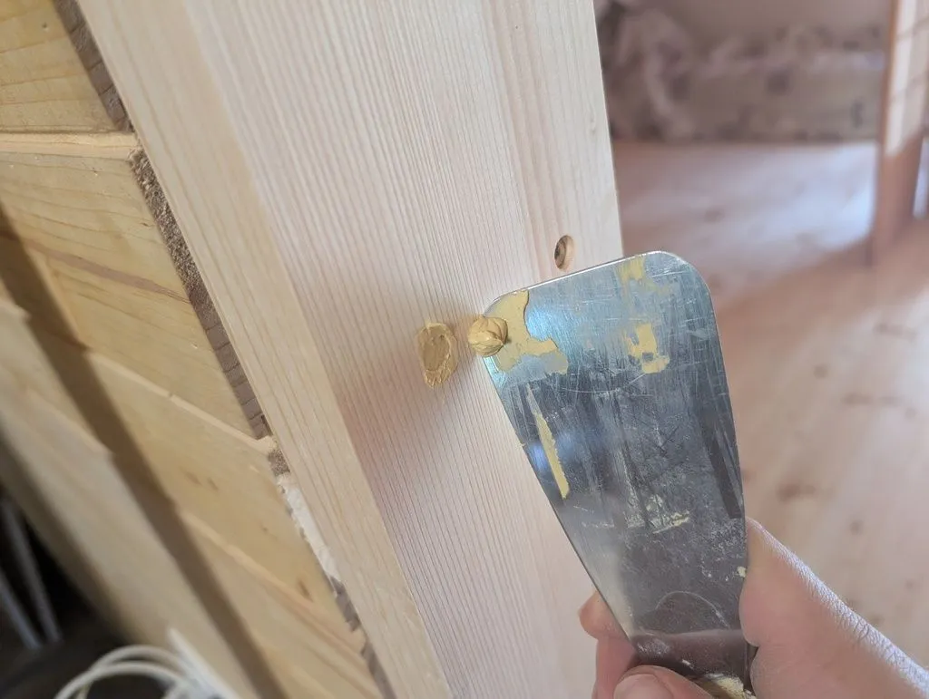 Filling the screw holes with wood filler.