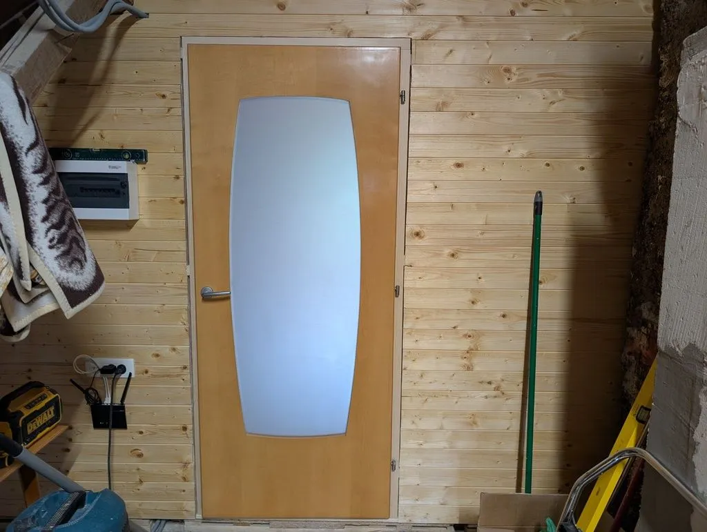The main entry door hung. The process of building the jambs and hanging the door is analogous to the process for the bathroom door; here is the finished result.
