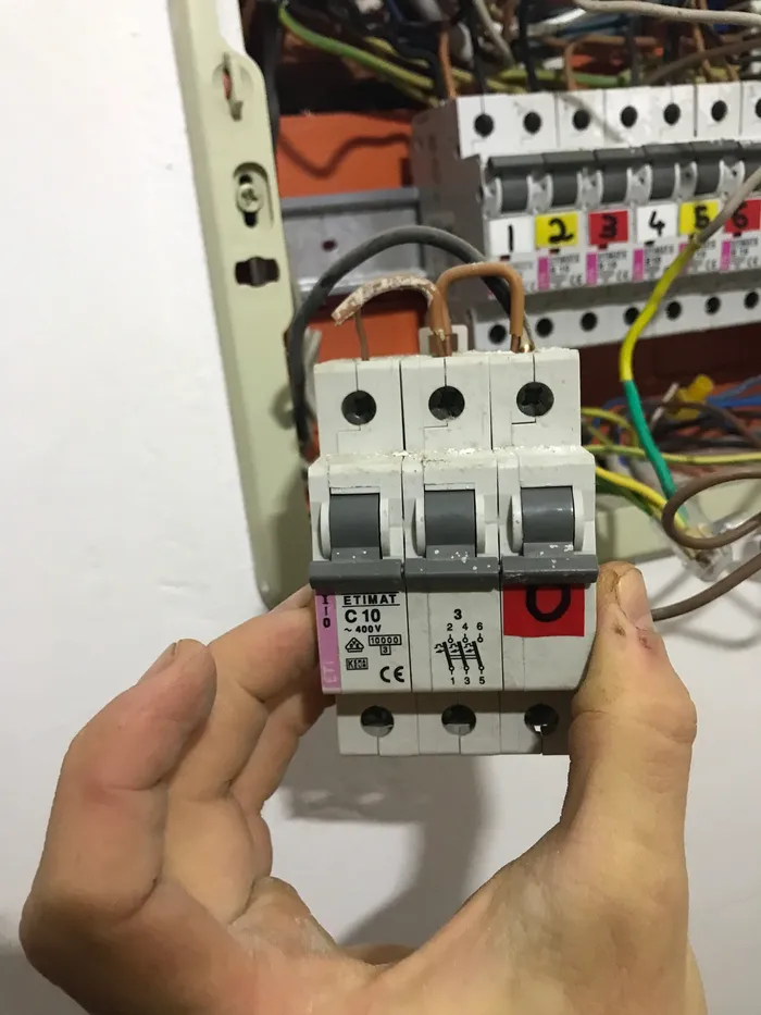 Close-up image of the jumper cables used to connect the three-phase main breaker's terminals.