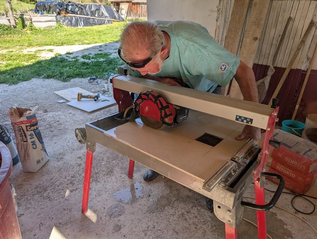Zdravko showing me how to cut tiles on the tile saw, which he lent me for the duration of the job. This was a wonderful tool to have—it is both precise and continuously wets the tiles with a jet of water, eliminating dust.