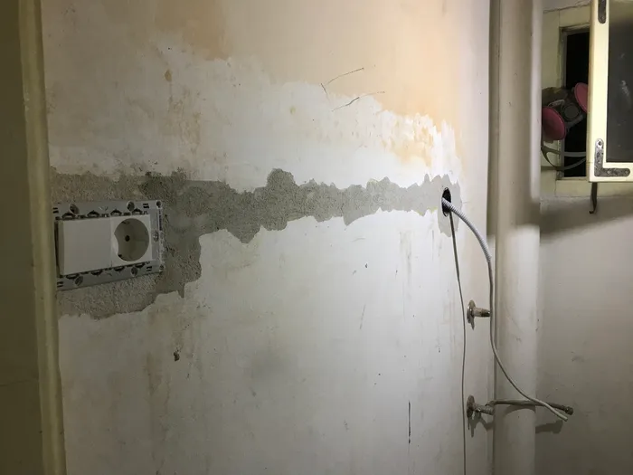 The installed new conduit, with the chase filled in with plaster.