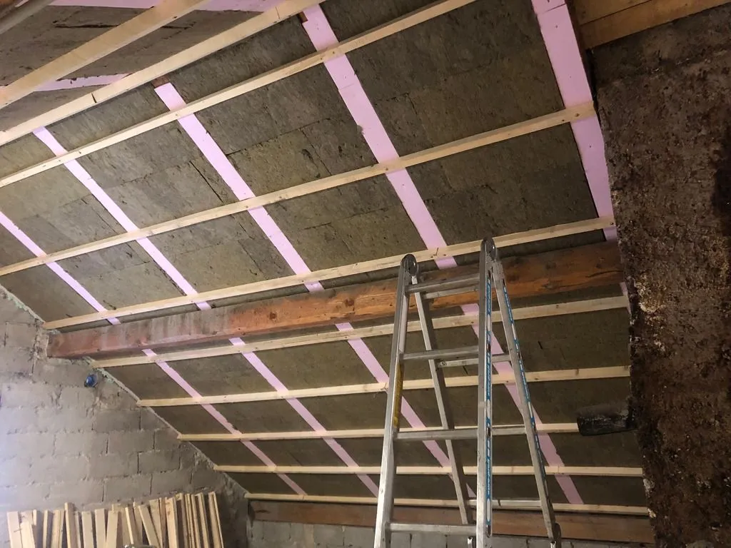 A grid of 50 mm thick wooden cross battens placed over the rafters will hold the final layer of rock wool in place.