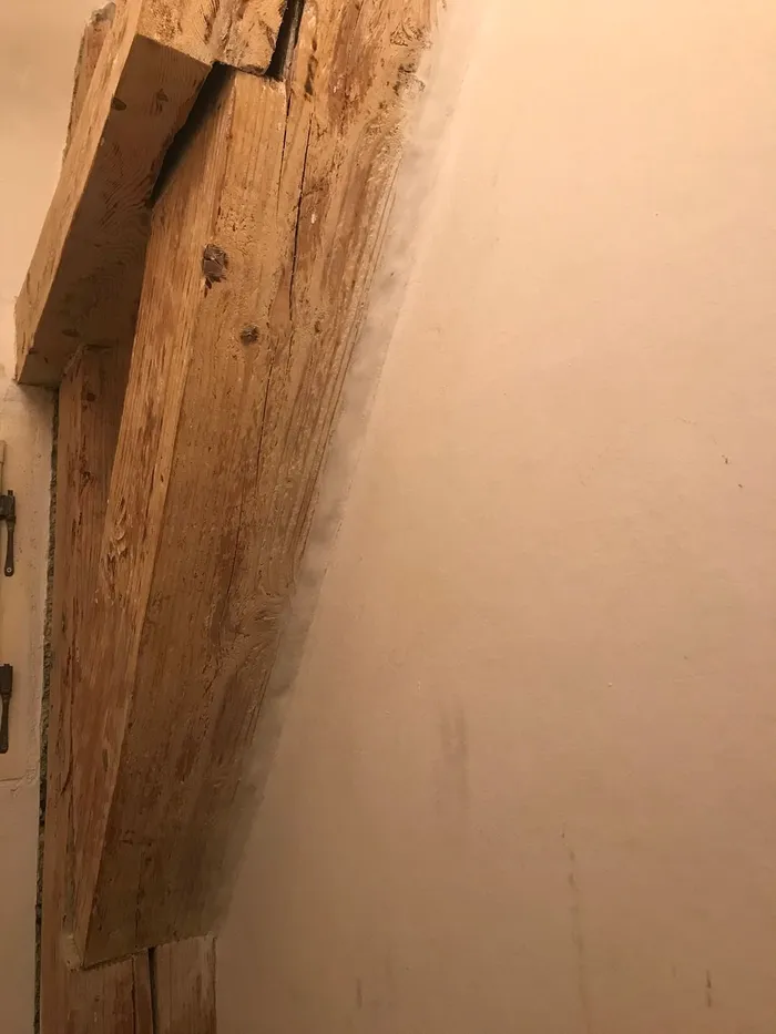 The gaps between timber members and wall patched with plaster.