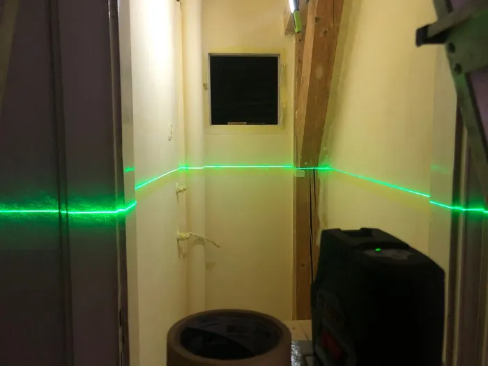 A laser level being used to lay out a level line around the room for the yellow accent.