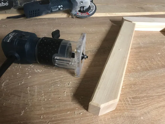 Using a router with a bevel bit to add a beveled profile around the edges of the ledgers