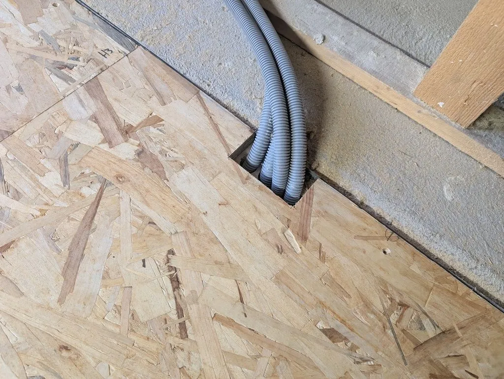 The notched board fitting nicely around the conduit.