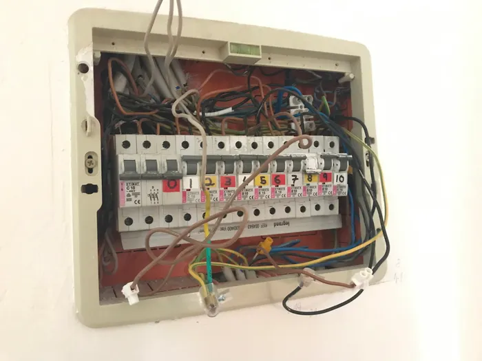 The original panel, showing chaotic wiring and no cover