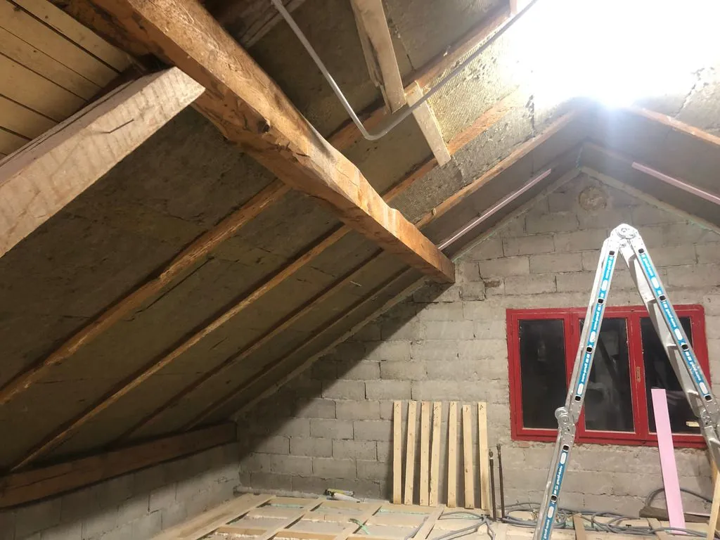 The first layer of rock wool continuing up the ceiling.