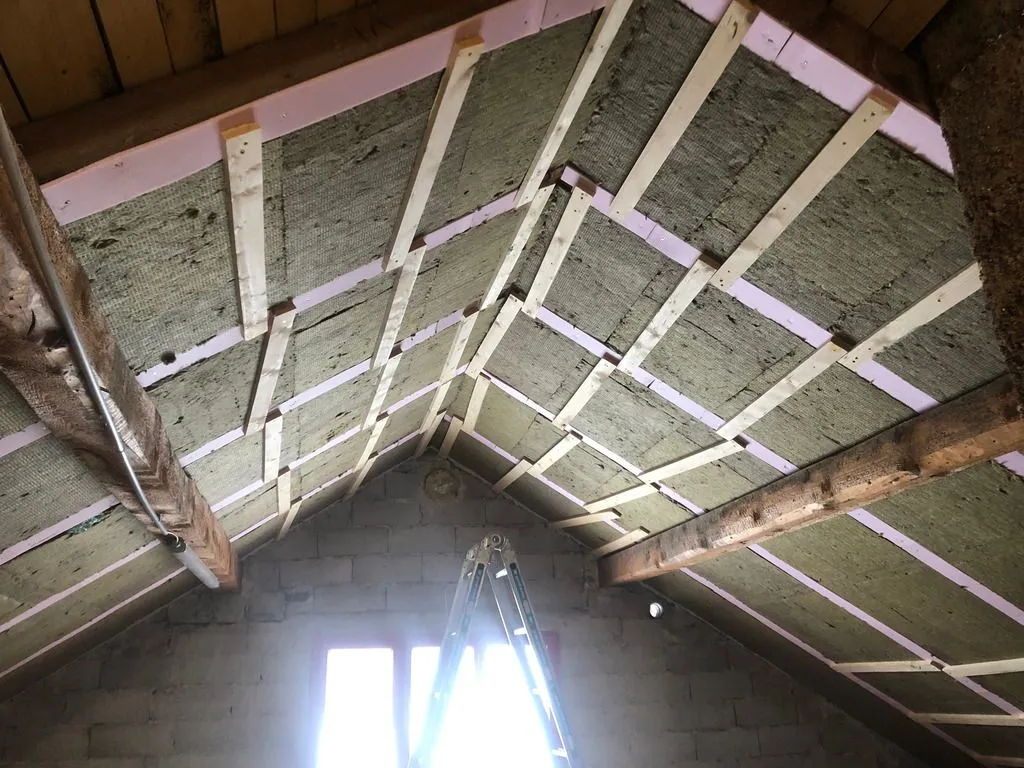 The second layer of rock wool batts continuing up the ceiling.